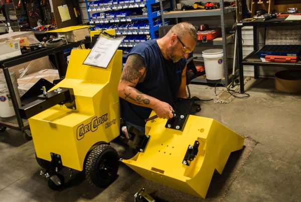 service technician repairing a cartcaddy material handling cart mover