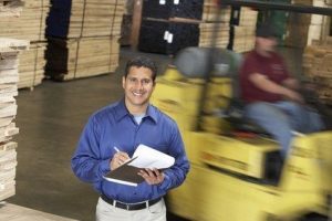 Manager in Lumber Warehouse Holding Clipboard