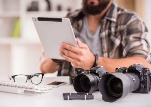 Young cheerful photographer with beard, while working in his office