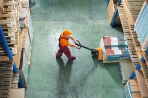 worker with fork pallet truck