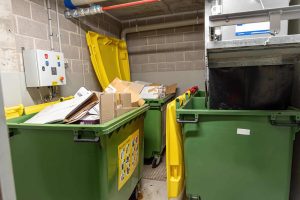 Image of a Tightly Packed Trash Room in Need of a Motorized Dumpster Tow