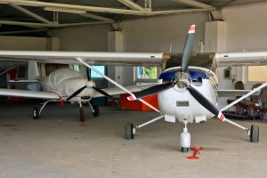 Two Airplanes Waiting to Be Pulled Out Of Storage by a Motorized Aircraft Caddy