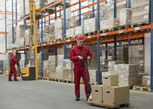 Warehouse workers struggling to organize materials without a motorized trailer dolly