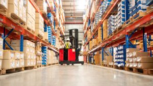 Warehouse Worker Operating a Motorized Trailer Dolly.